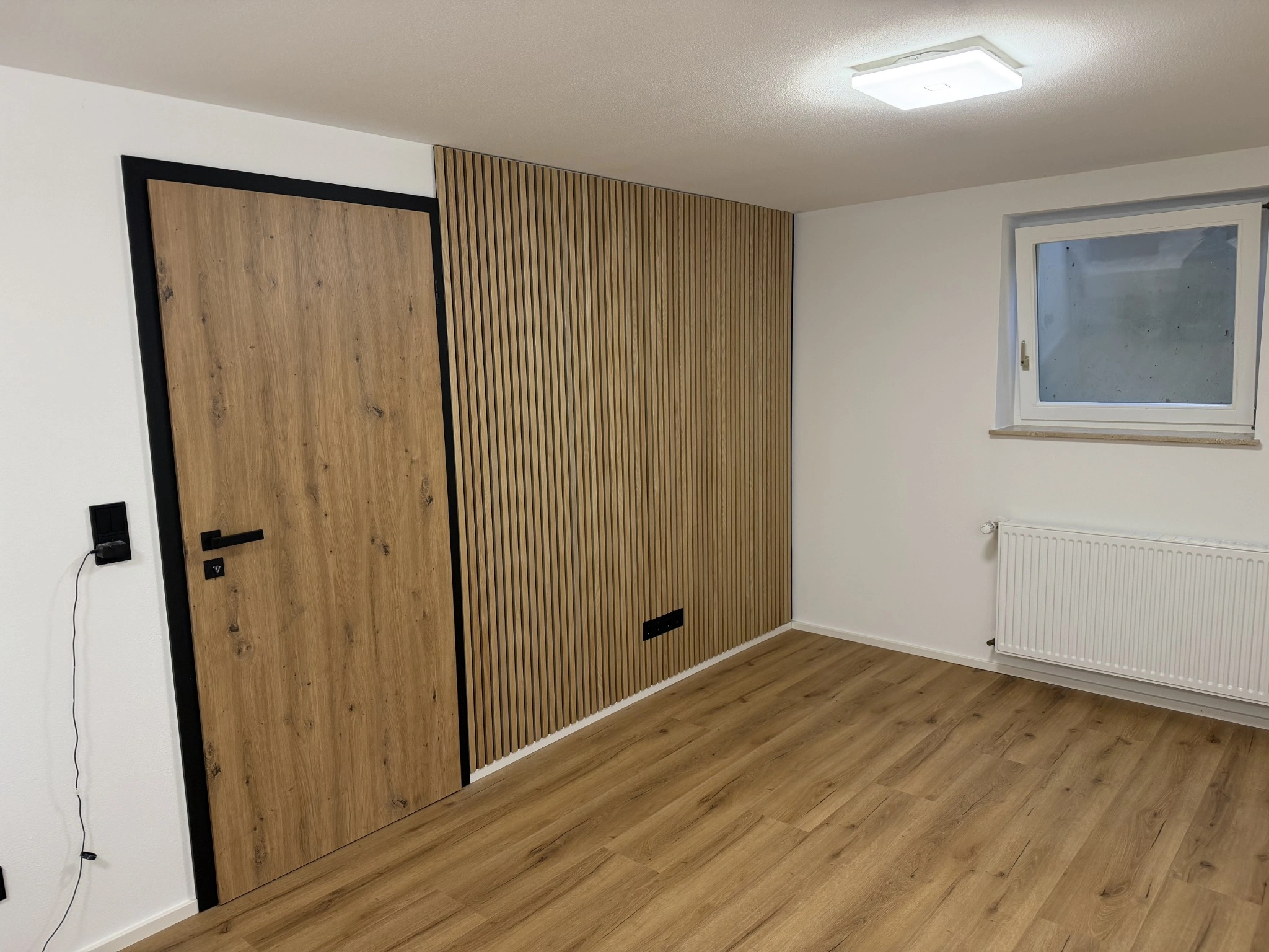Wandlamellen neben einer Tür in Holzoptik