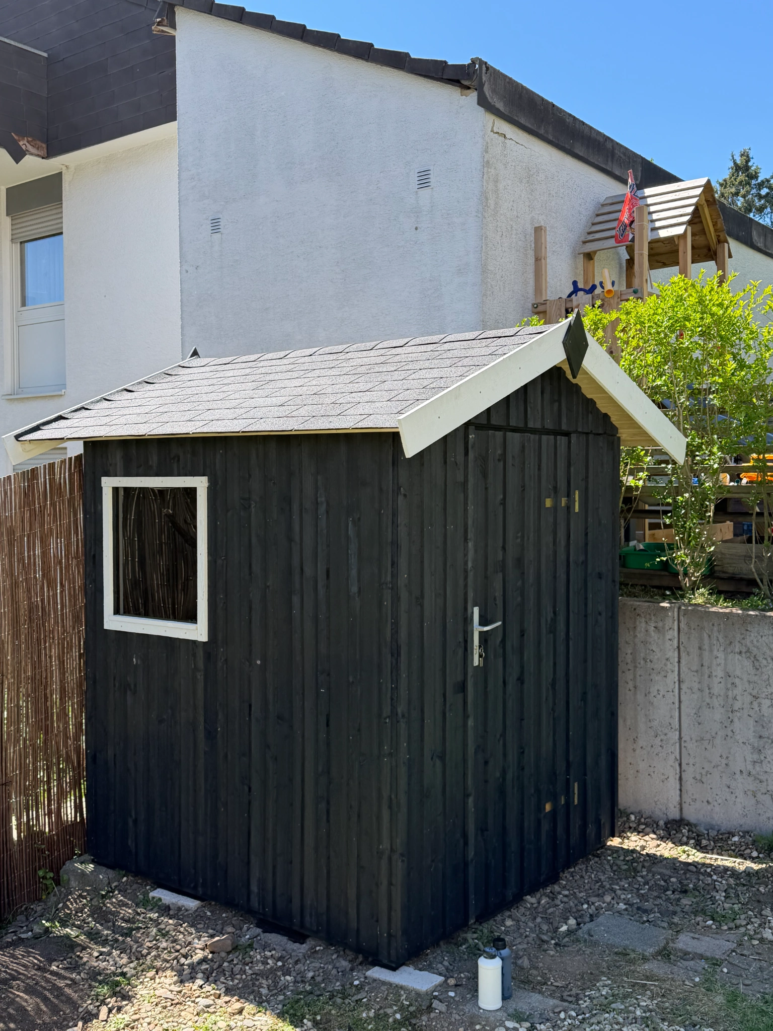 Dunkles Gartenhaus mit hellen Dachblenden